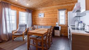 a kitchen and dining room with a table and chairs at Lekotti Vacation Club in Savonranta