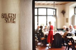 a woman in a red dress standing in a restaurant at Brauereigasthof-Hotel Roter Ochsen in Ellwangen