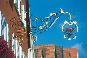 a sign with a cow on it hanging from a building at Brauereigasthof-Hotel Roter Ochsen in Ellwangen
