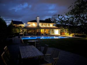 a house with a swimming pool at night at B&B De Alffarhoeve in Hamme