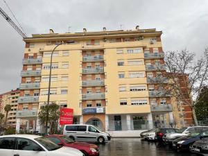 a large yellow building with cars parked in a parking lot at La Repera Jaén in Jaén