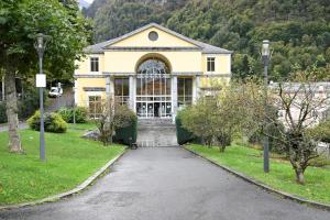 a large yellow house with a driveway at Appartement chaleureux à Cauterets - 35 m² - Casier à skis in Cauterets