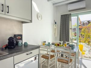 a kitchen with a table and chairs and a window at ANETON Residences in Karavostasi