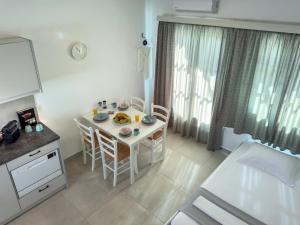 a kitchen and dining room with a table and chairs at ANETON Residences in Karavostasi