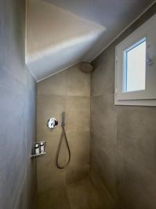 a bathroom with a shower with a shower head at ANETON Residences in Karavostasi