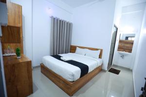 a bedroom with a large bed in a room at Hr residency in Kozhikode +12 photos