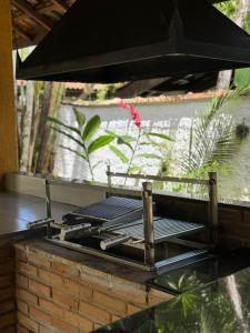 a grill sitting on top of a brick wall at Casa Amarela in São Sebastião
