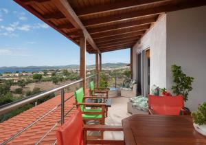 a balcony of a house with chairs and a table at Luxury Apartment in Nikiti