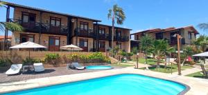 a villa with a swimming pool and a resort at Pousada Catavento in Flecheiras