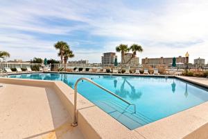 una gran piscina con sillas y palmeras en Dolphin Point 702A, en Destin