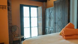 Un dormitorio con una cama y una ventana grande. en Casa Abuela Ana, en Vélez-Málaga