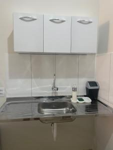 a kitchen counter with a sink and white cabinets at Studio 38 - Próx ao Parque do Sabiá Aeroporto e Shopping in Uberlândia +10 photos