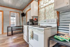 una cocina con una estufa blanca horno superior junto a una mesa en Cozy Couples Cottage with View Near Canyon Lake!, en Canyon Lake