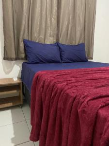 un letto con coperta rossa e cuscini blu di Apartamento Completo - Piscina, Pet Friendly, Academia No coração da Cidade a Feira de Santana