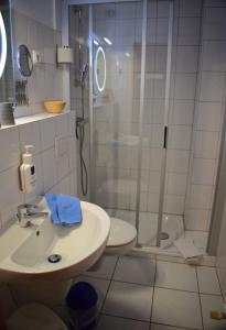 a bathroom with a shower and a sink and a toilet at Hotel Haus am Meer in Büsum