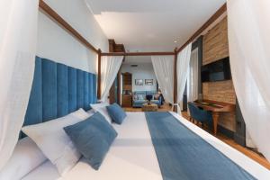 a bedroom with a large bed with blue and white pillows at La Casa Azul Boutique Hotel in Andújar