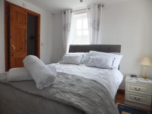 a bedroom with a large bed with white sheets and pillows at West View Farm in Louth