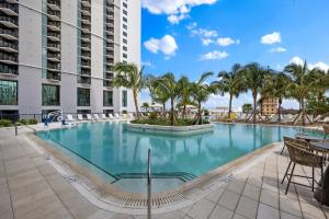 迈阿密On 44th Floor! Condo w The Best Views & Free Parking的一座大型游泳池,在一座建筑前种有棕榈树