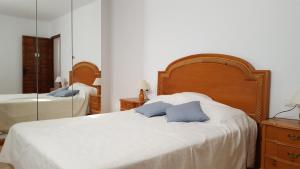a bedroom with a bed with two blue pillows on it at El Capistrano Sur in Nerja