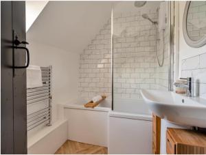 Darla Cottage في ثورنتون دالي: حمام أبيض مع حوض ودش