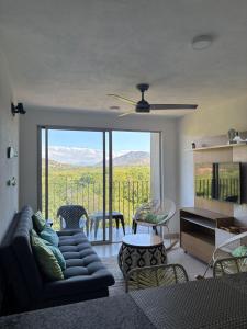 Una sala de estar con un sofá y una ventana grande. en Conjunto Bello Horizonte Plaza, en Santa Marta