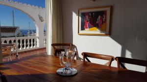 una mesa con copas de vino en la parte superior de un balcón en El Capistrano Sur, en Nerja