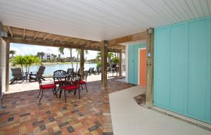 フォートマイヤーズビーチにあるEndless Tides 1 by Sun Palace Vacationsのテーブルと椅子付きのパティオが備わる客室です。