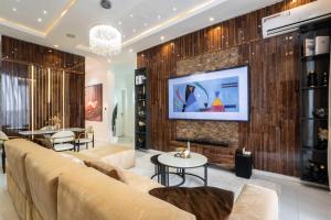 un soggiorno con un divano e una TV a parete di 247 Electricity 2 bedrooms Lux Ikate with PS5 opt a Lekki