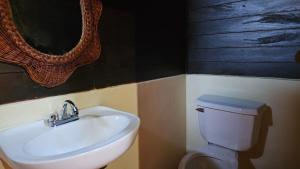 a bathroom with a white sink and a toilet at Cabañas Yax-ha in Arroyo Agua Azul +35 photos