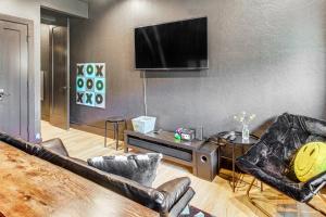 a living room with a flat screen tv on a wall at Walk to Lake Home with Game Room in Medicine Park! in Medicine Park