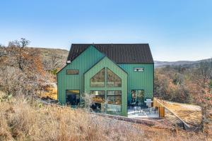 a green house with a black roof at Walk to Lake Home with Game Room in Medicine Park! in Medicine Park