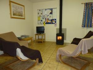 a living room with two chairs and a fireplace at Palace Farm Courtyard and Granary Rooms in Doddington +34 photos