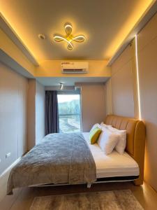 a bedroom with a bed with a ceiling fan and a window at Luxury 1BR across Okada, Solaire in Manila