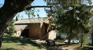 a building with a table and a chair in front of it at Agriturismo Cuore Verde La Madreselva a Spello in Spello +20 photos