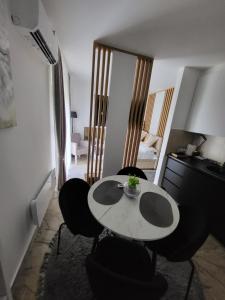 a room with a table and chairs and a bedroom at Apartman Karolina in Banja Koviljača