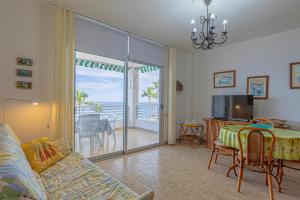 Sala de estar con sofá y mesa con vistas al océano en Casa Leila, en Puerto Naos