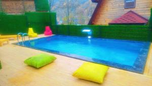 a large swimming pool in a backyard with a toy house at Şifaköy Bungalov in Sapanca