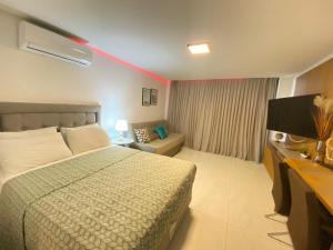 a hotel room with a bed and a couch at UNITY Cabo Branco by PenareiaTurBr in João Pessoa