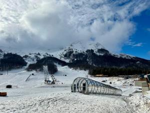 a snow covered mountain with a ski slope with a building at Nonno Leo in San Massimo