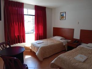 a hotel room with two beds and a window at Hostal Bond in Huaraz