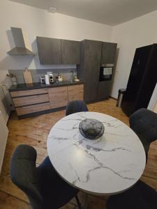 a kitchen with a marble table and chairs in a room at Appartement Spacieux 4 Chambres in Flers-en-Escribeus +20 photos