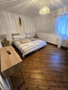 a bedroom with a bed and a table in it at Appartement Spacieux 4 Chambres in Flers-en-Escribeus