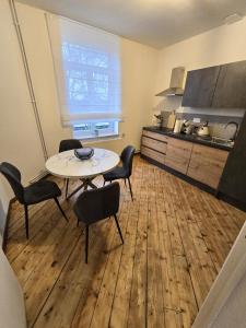 a room with a table and chairs and a kitchen at Appartement Spacieux 4 Chambres in Flers-en-Escribeus