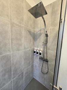 a shower with a shower head in a bathroom at Appartement Spacieux 4 Chambres in Flers-en-Escribeus