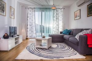 een woonkamer met een bank en een tv bij Apartment Belavista in Split