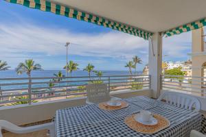 Una mesa en un balcón con vista al mar. en Casa Leila, en Puerto Naos
