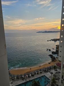 une vue de la plage depuis un immeuble dans l'établissement Departamento vista al mar y acceso a playa en bahía de Acapulco - Torres Gemelas, à Acapulco