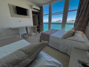 Cama ou camas em um quarto em Grand Hotel Guarujá - A sua Melhor Experiência Beira Mar na Praia!