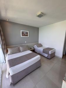 Cama ou camas em um quarto em Grand Hotel Guarujá - A sua Melhor Experiência Beira Mar na Praia!