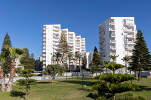 een groot appartementencomplex met palmbomen in een park bij Todimer Ohana Beach in Salobreña